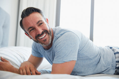 Man lying on bed smiling