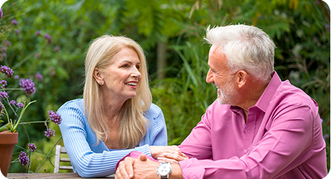 Man and women looking at each other sitting at a table smiling